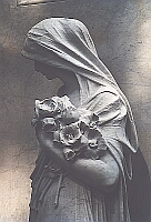 Relief-Skulptur vor einem Marmor-Grabstein